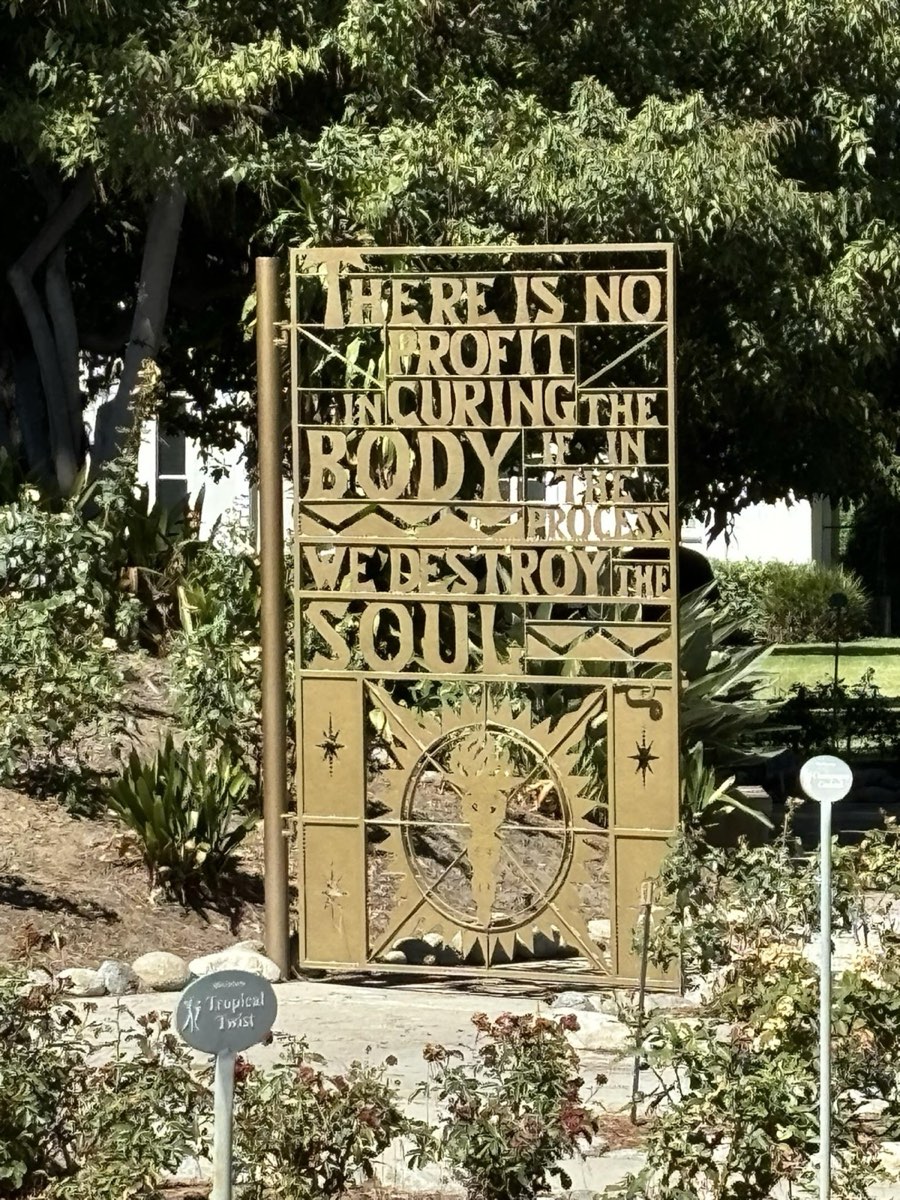 Placa dourada no jardim do City of Hope com o lema da instituição